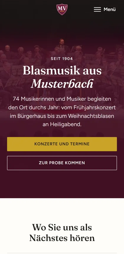 Die Startseite des Demovereins „Musikverein Harmonie“ auf dem Handy: ein dunkel getöntes Foto eines Blasorchesters, darauf mittig die Überschrift „Blasmusik aus Musterbach“ und die Knöpfe „Konzerte und Termine“ und „Zur Probe kommen“. Das Wappen steht in der Mitte des Kopfes.