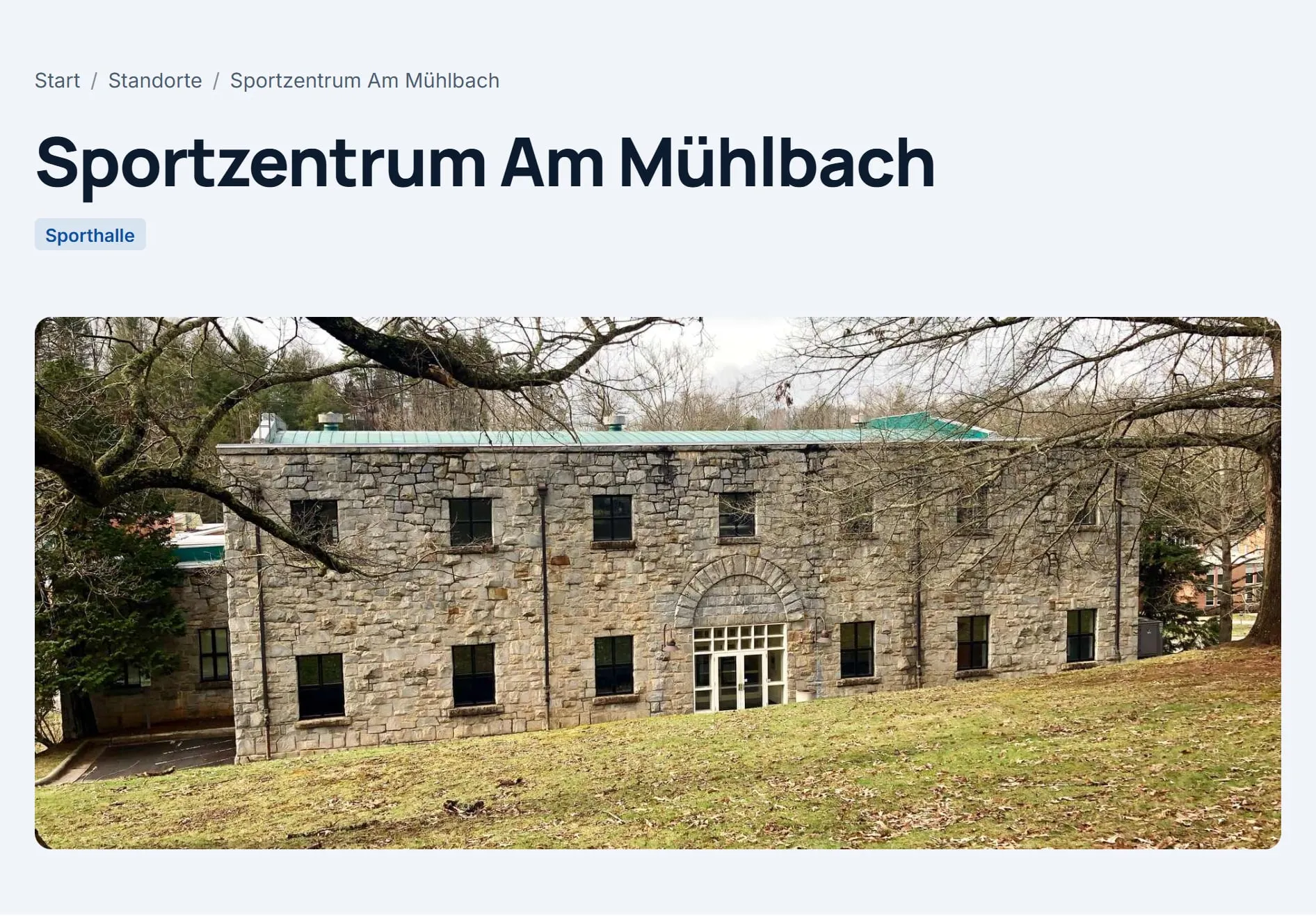 Die Seite des Standorts „Sportzentrum Am Mühlbach“ auf der Website: Titel, Standortart „Sporthalle“ und ein großes Bild.
